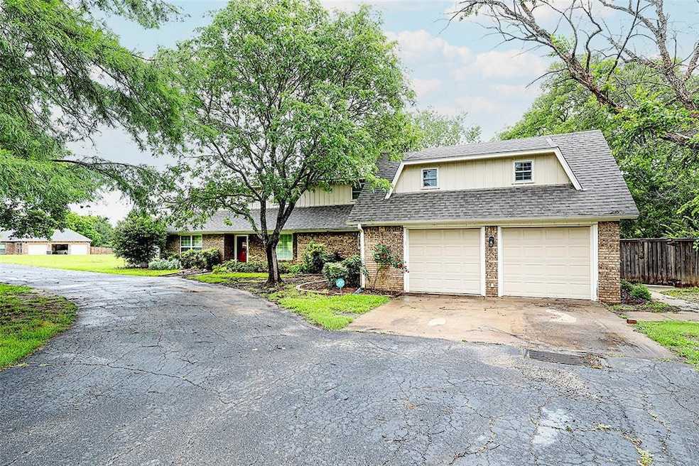 View of front of property with brick siding, asphalt driveway, and a shingled roof