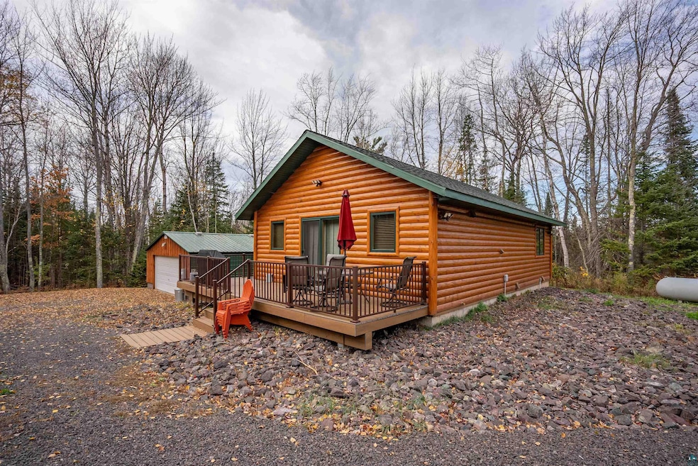 Log-style house featuring a deck, an outbuilding, 
