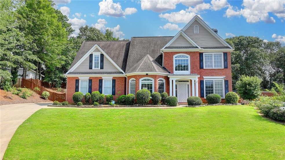 View of front of home featuring brick siding and roof with shingles