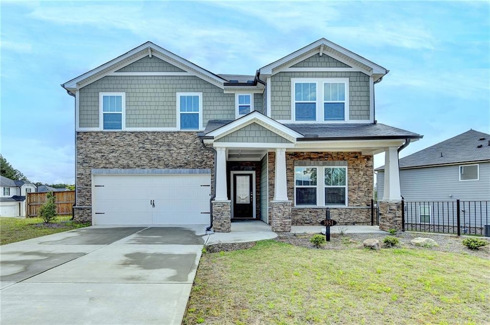 Craftsman house with an attached garage, fence, an