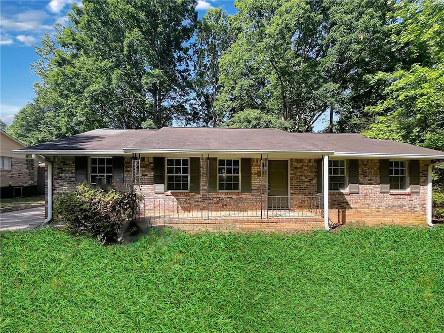 Ranch-style house featuring a porch, brick siding,