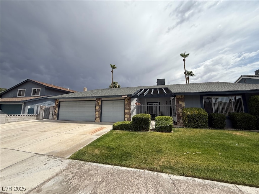 Single story home with a garage, stone siding, a f