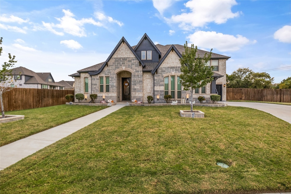 View of front of home featuring stone siding, driveway, and brick siding