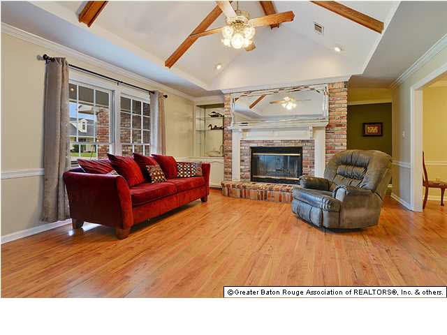 Family room with wood laminate flooring, high beam