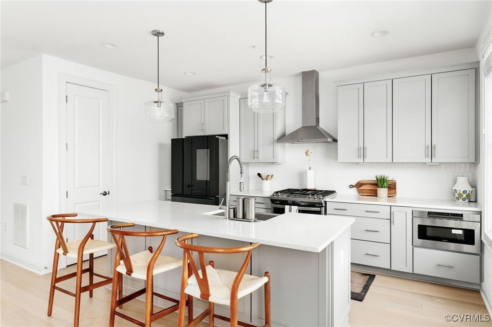 The kitchen features quartz countertops, tile back