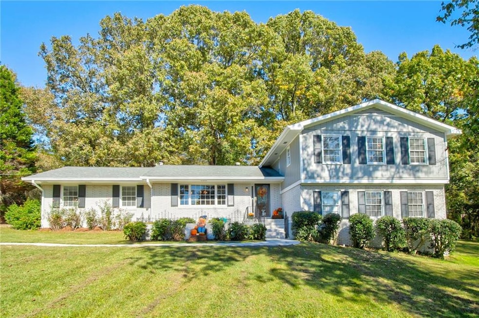 Tri-level home with brick siding and a front yard