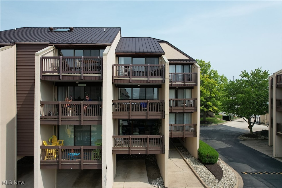 Rear view of house featuring a standing seam roof, a metal roof, and a balcony