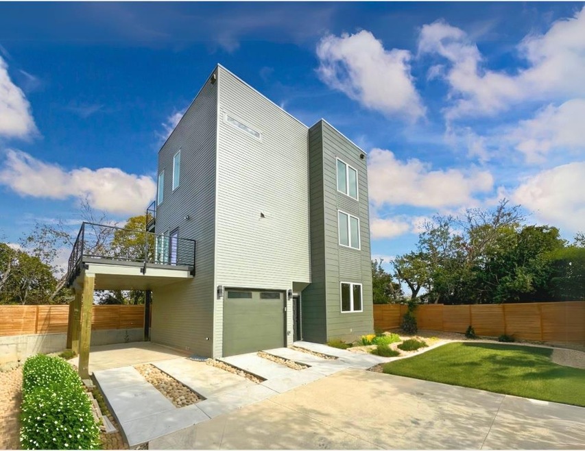 Back of house featuring a balcony, driveway, a pa