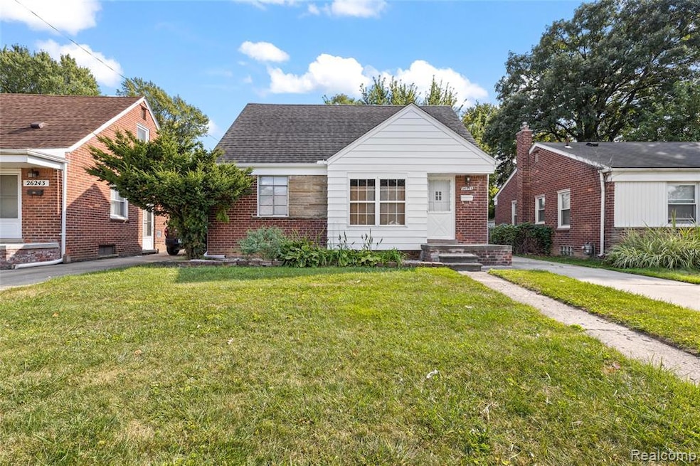 Bungalow featuring a front lawn, brick siding, and a shingled roof