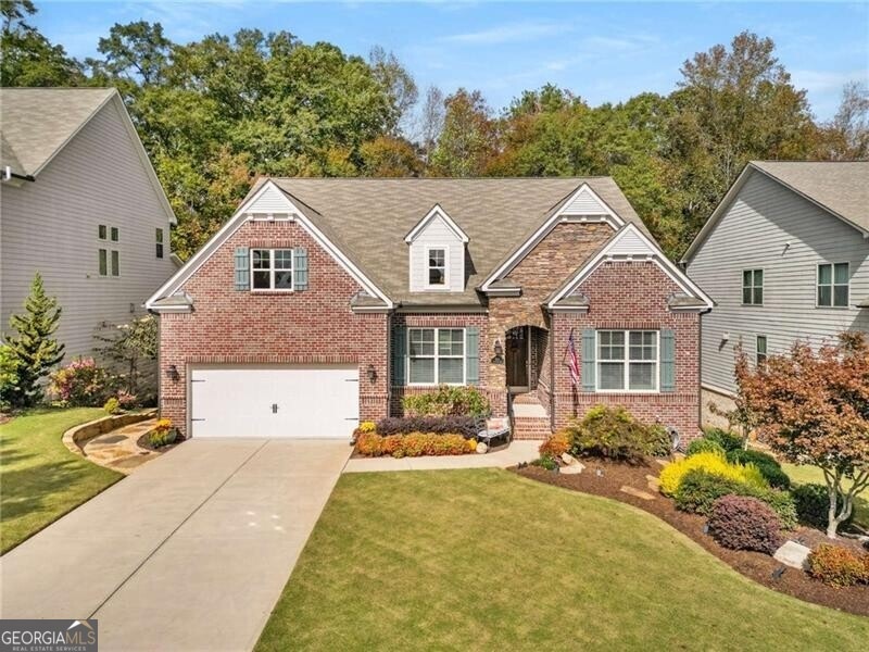 View of front of home with a front yard and a gara