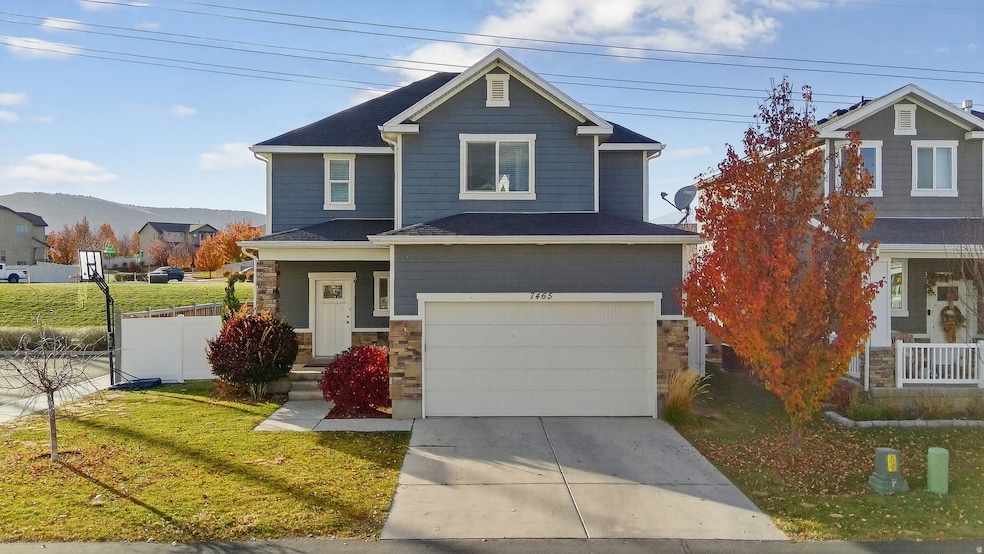 View of front of house with stone siding, concrete driveway, and a garage