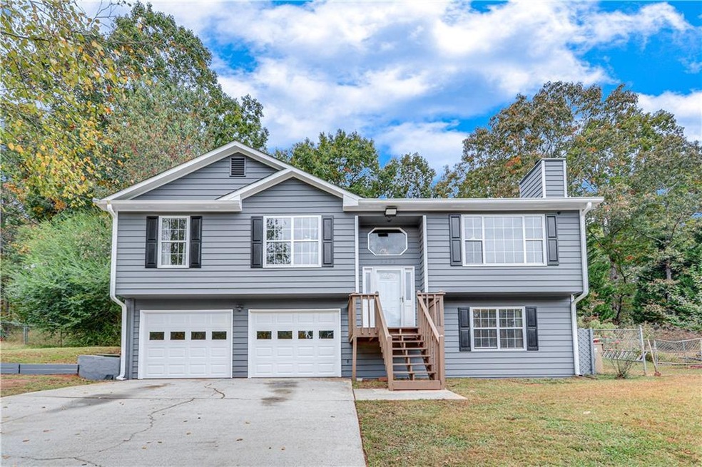 Raised ranch featuring a front yard and a garage