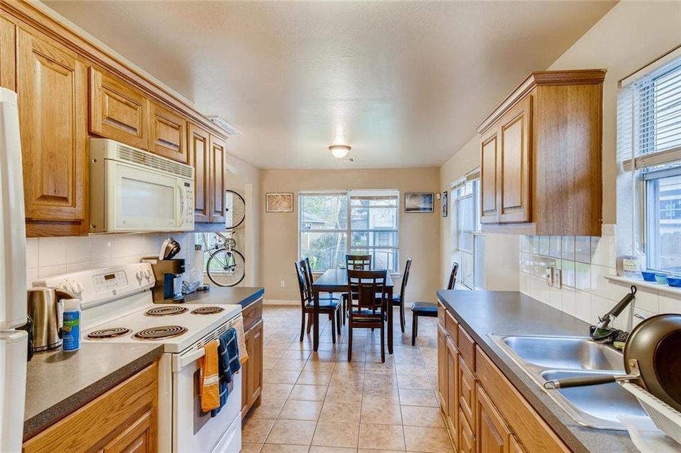 Kitchen with tasteful backsplash, white appliance