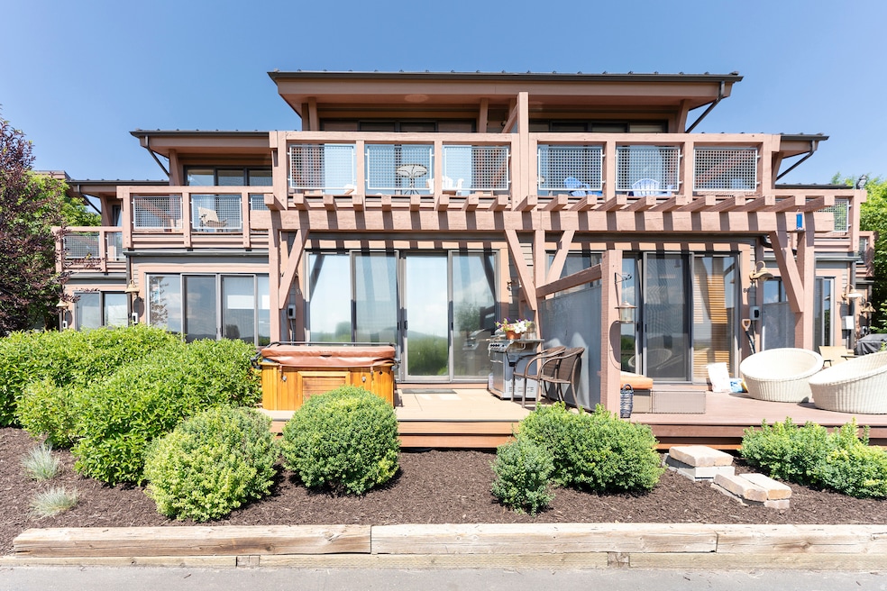 Rear view of house featuring a hot tub, a deck, and a balcony