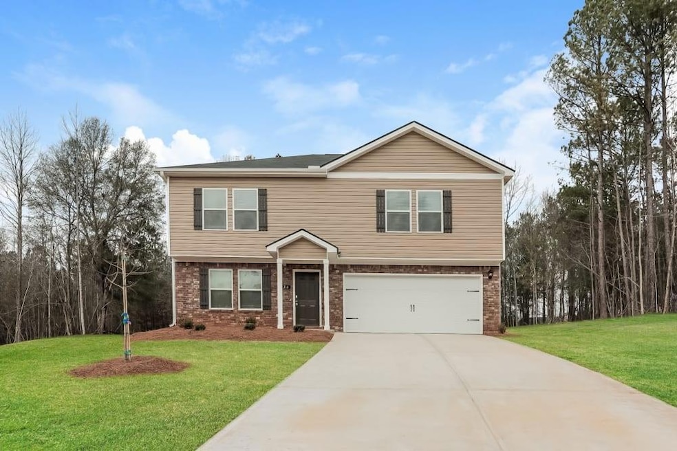 View of front facade featuring a front yard and a garage