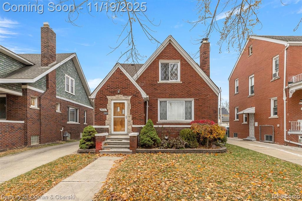 View of front of home featuring a chimney and brick siding