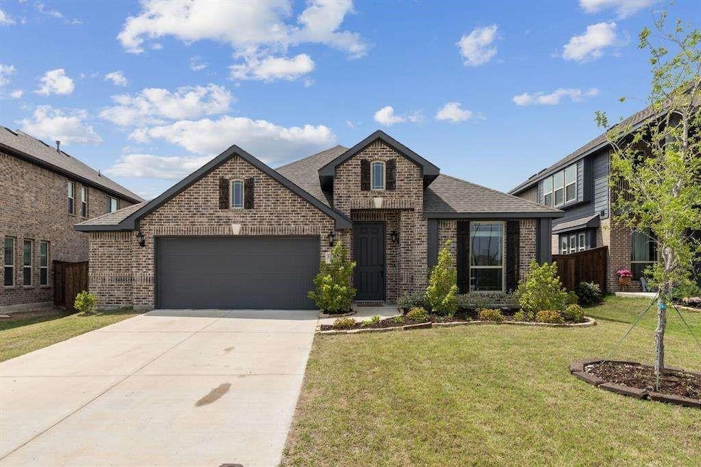 View of front of house with a garage and a front y