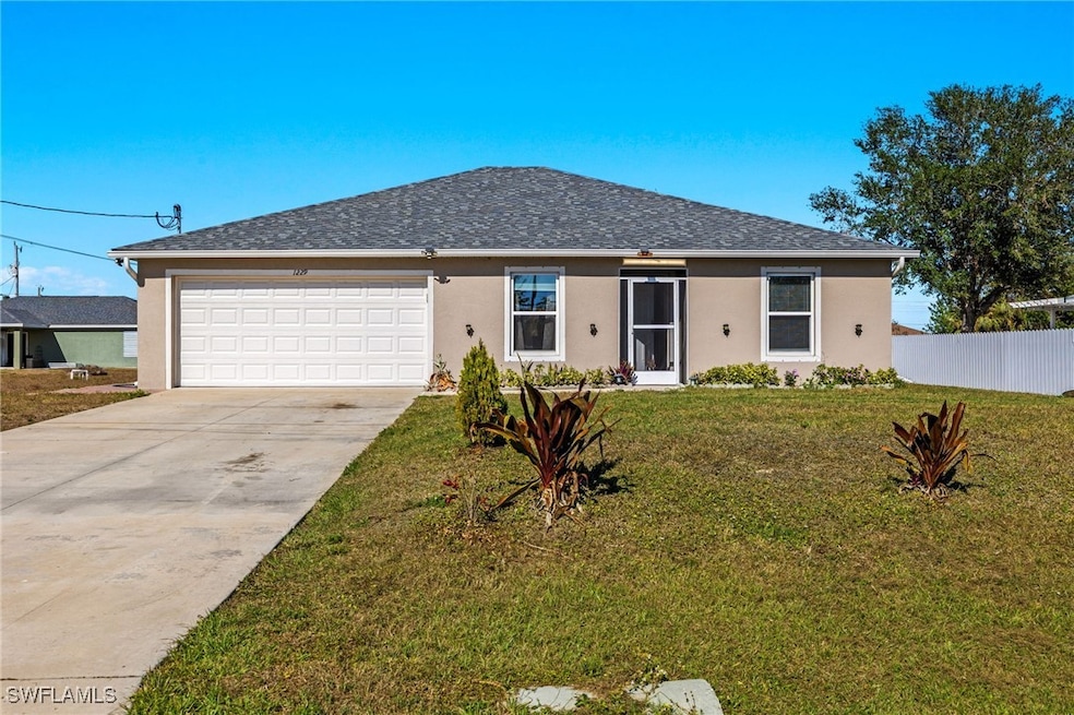 Ranch-style house featuring a front lawn and a gar