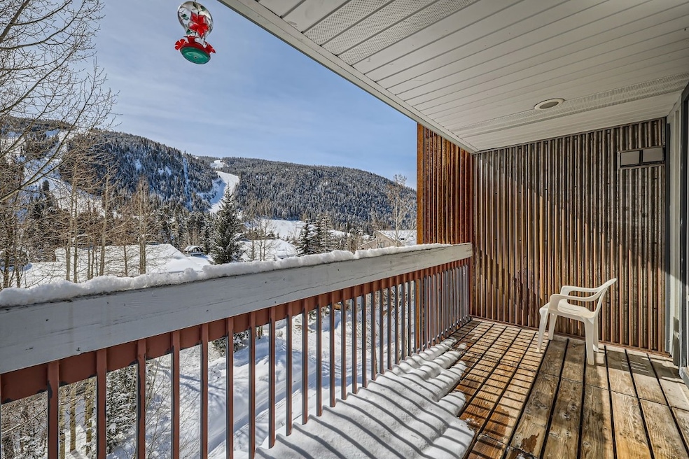 Snow covered back of property with a mountain view