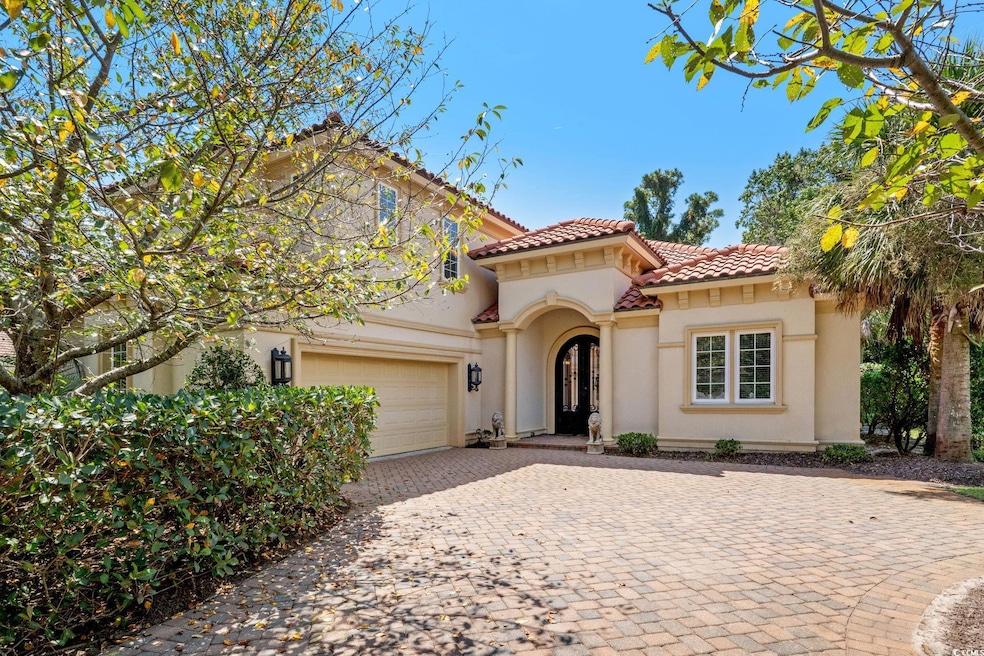 Mediterranean / spanish house with a tile roof, decorative driveway, stucco siding, and a garage