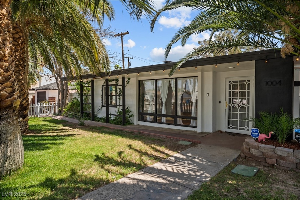 Back of house featuring fence, stucco siding, and