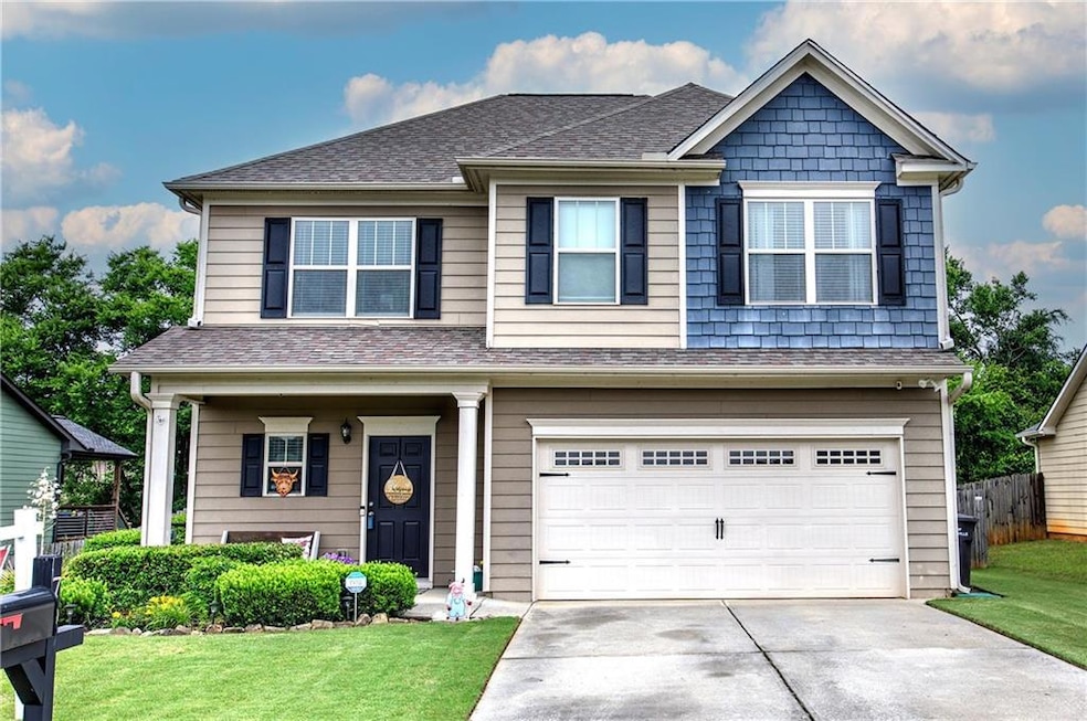 View of front of home with concrete driveway, a shingled roof, and a garage