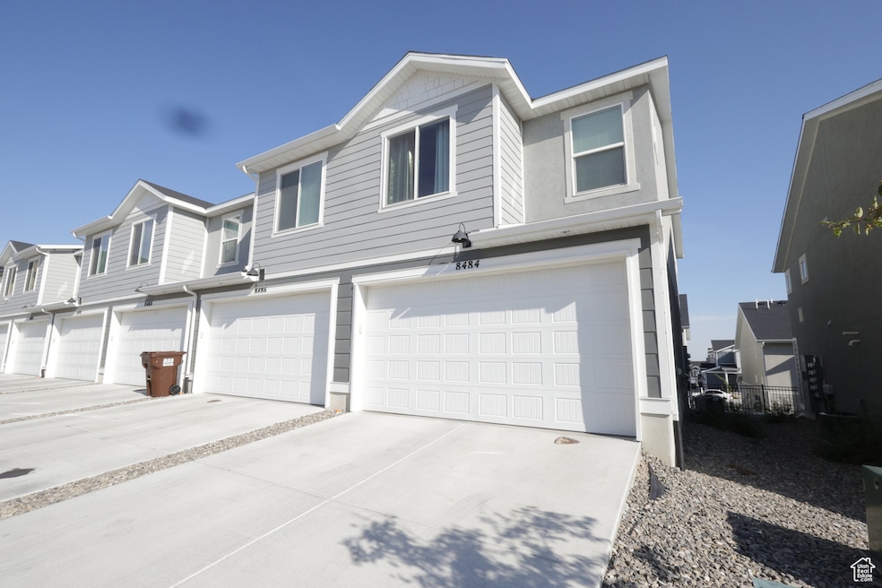 Traditional-style home featuring concrete driveway and an attached garage