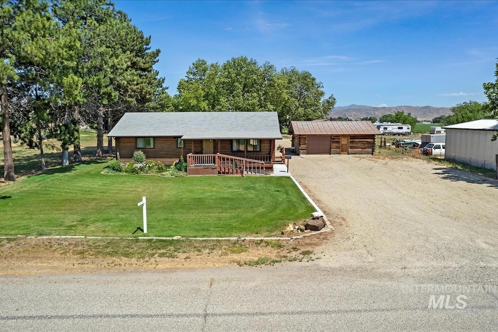 Log-style house with covered porch, a front lawn, a mountain view, log siding, and an outdoor structure