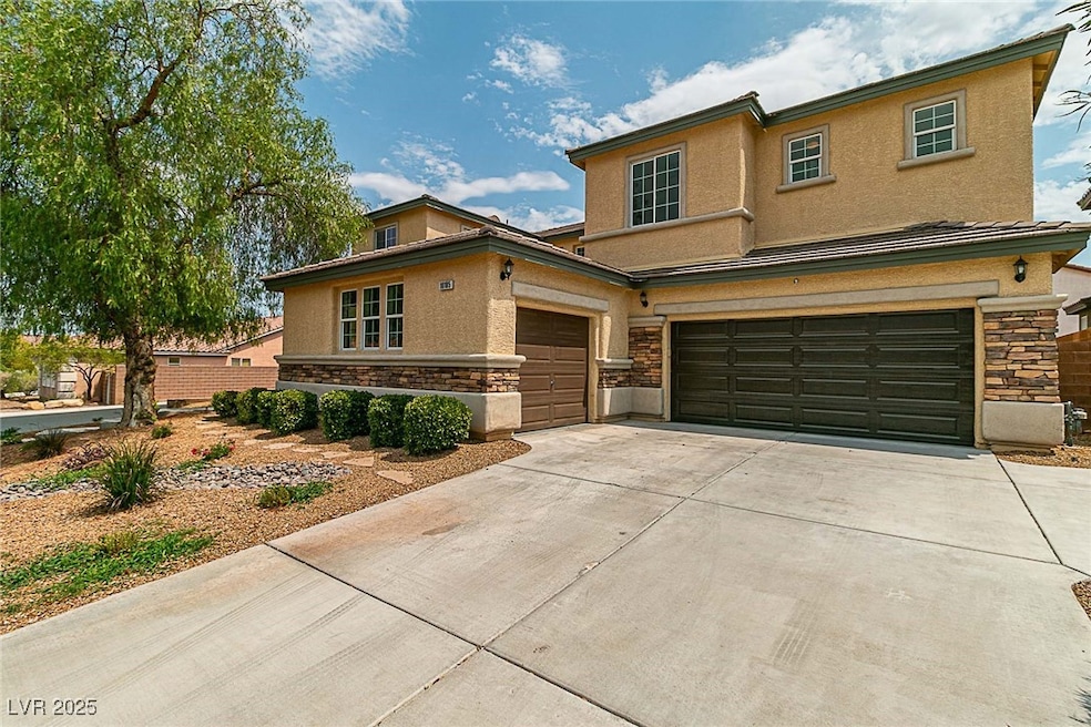 View of front of house with stone siding, stucco siding, and driveway