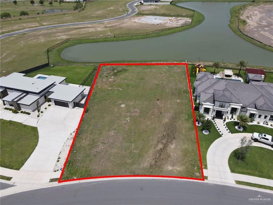 Aerial perspective of suburban area featuring a nearby body of water and property boundaries highlighted