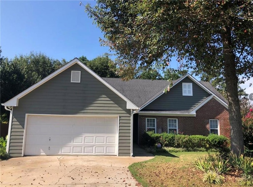 View of front of house featuring driveway, a garage, and brick siding