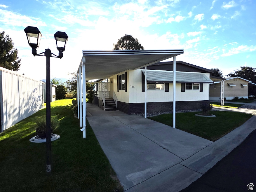 1680 sq ft mobile home with a front lawn, two carports, and concrete driveway