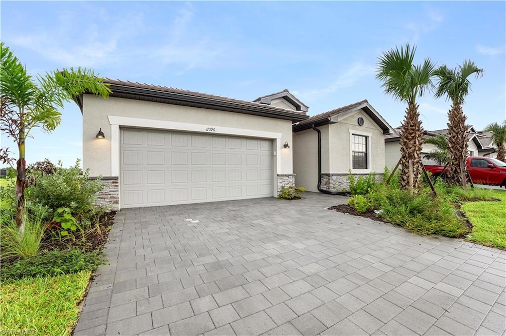Single story home featuring a garage, stone siding