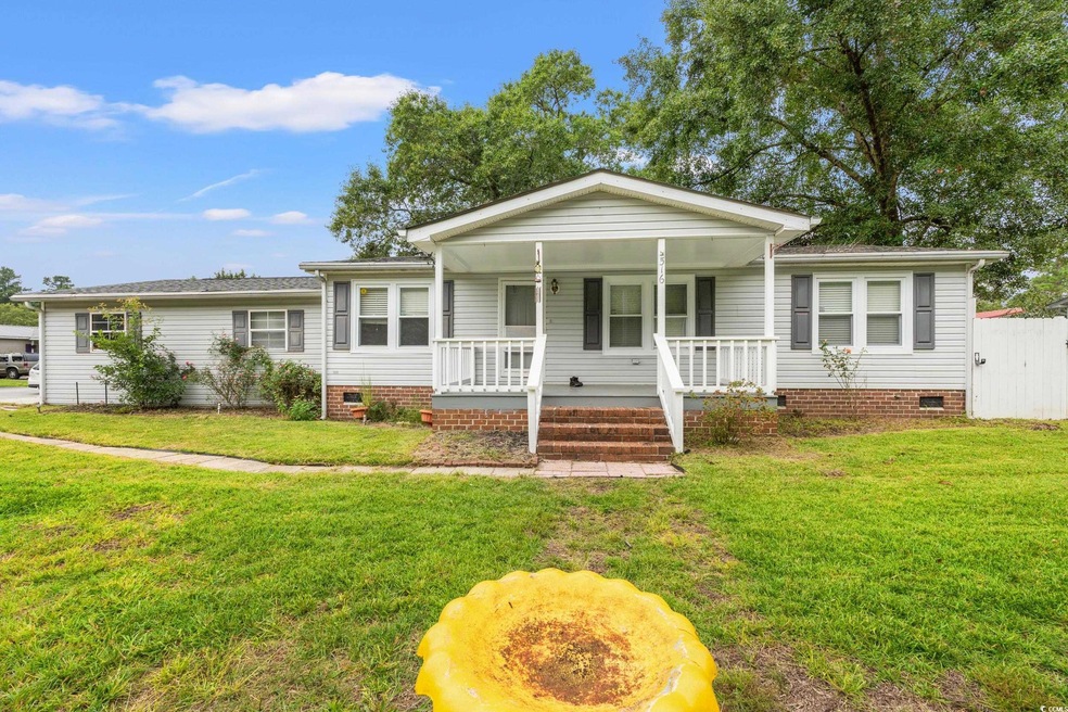 Ranch-style home with covered porch and a front la