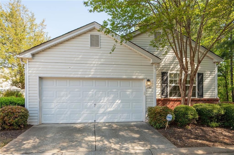 View of front facade featuring a garage, brick sid