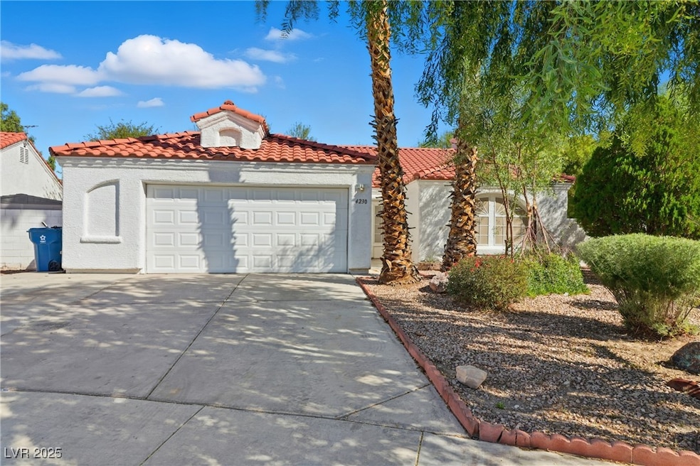 Mediterranean / spanish house featuring driveway, a tile roof, stucco siding, and a garage