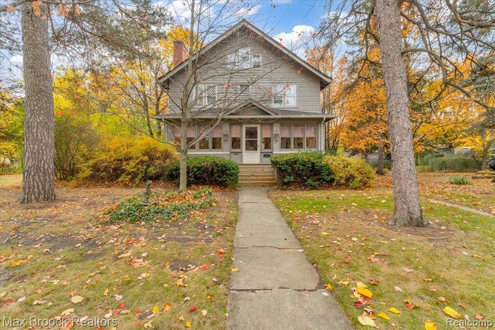 Traditional style home with a sunroom, a chimney, and a front yard