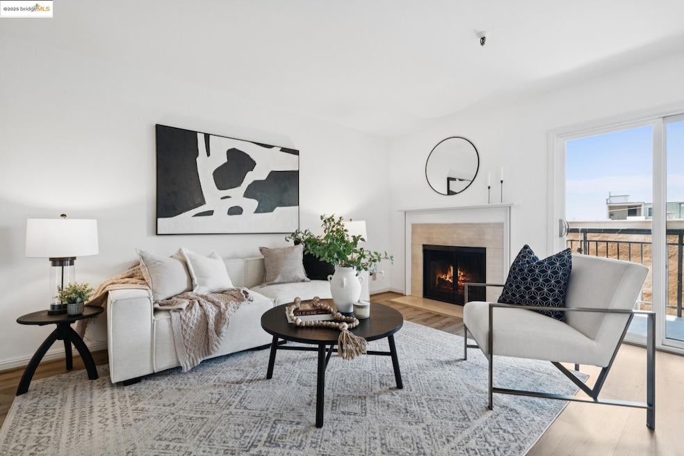 Living area featuring healthy amount of natural light, wood finished floors, and a tiled fireplace