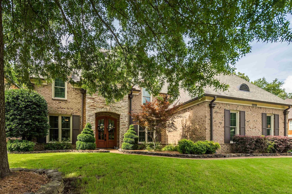 View of front facade with a front yard, brick siding, and french doors