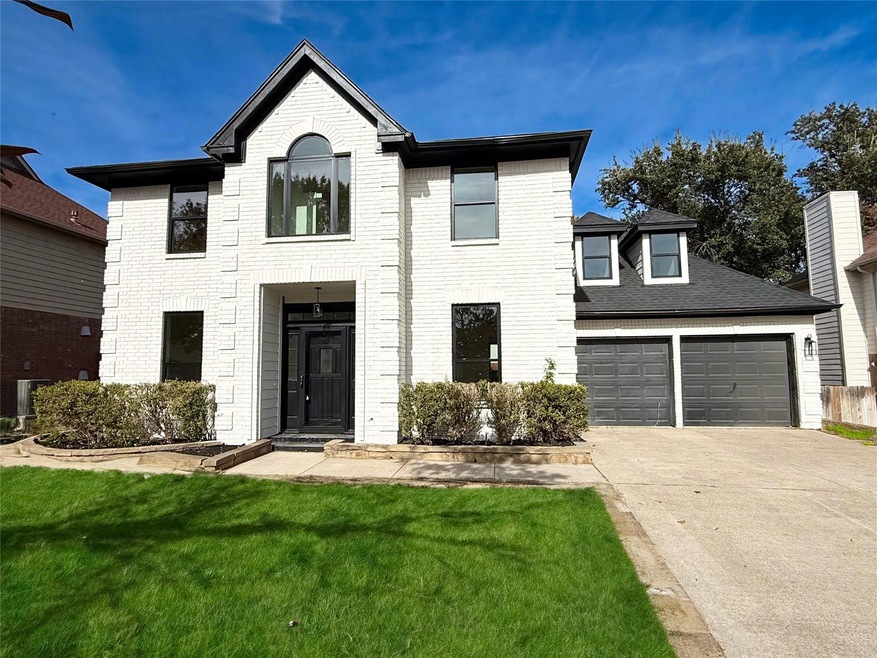 View of front facade featuring a front yard and a garage