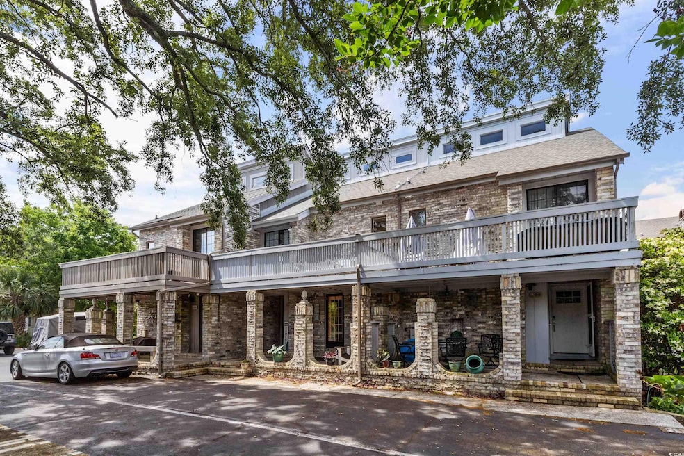View of front of home featuring a balcony and stone siding