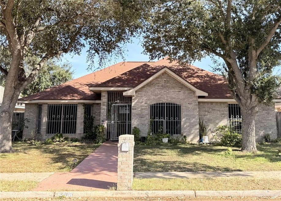 Single story home featuring brick siding and roof with shingles