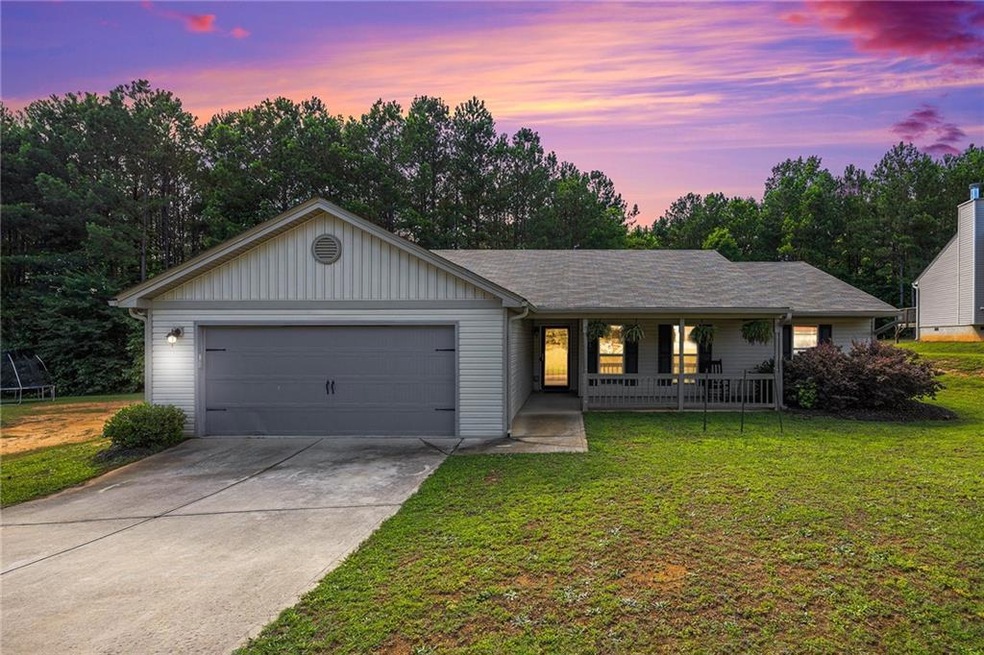 Ranch-style house with a garage, a porch, and a la