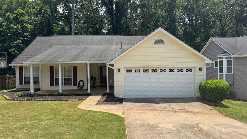 View of front of property featuring a porch, a garage, driveway, a front lawn, and a chimney
