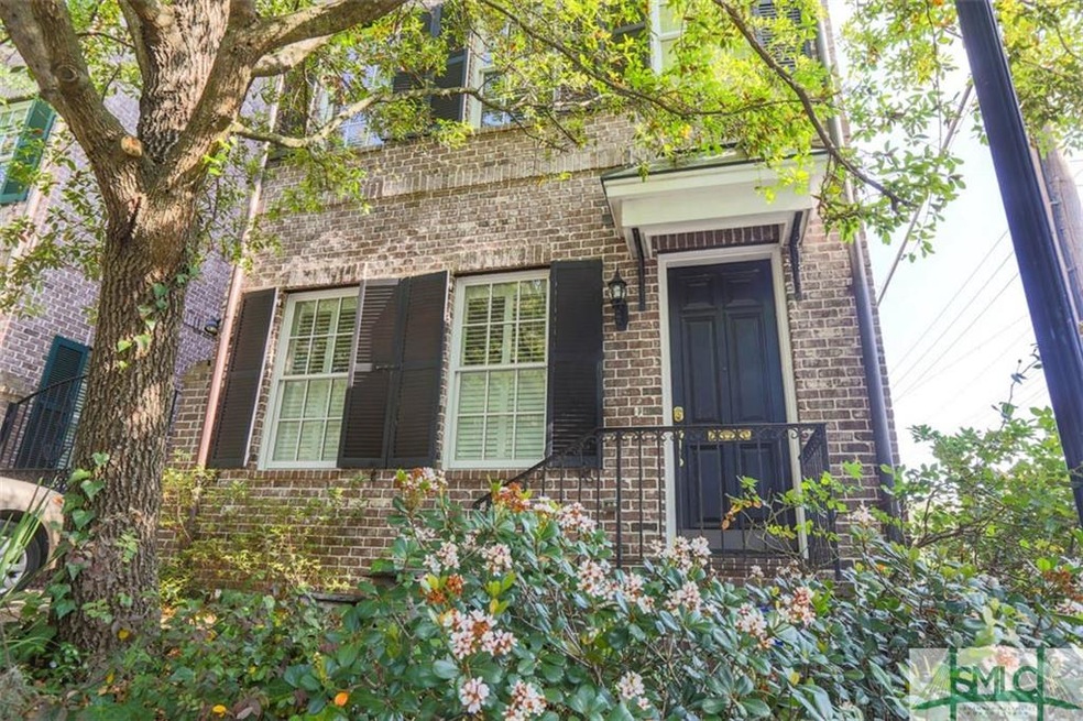 Front of house, framed by greenery.