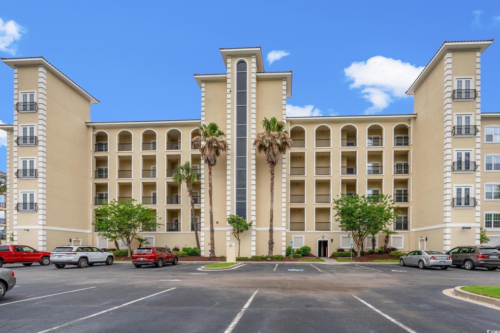 View of building exterior with uncovered parking
