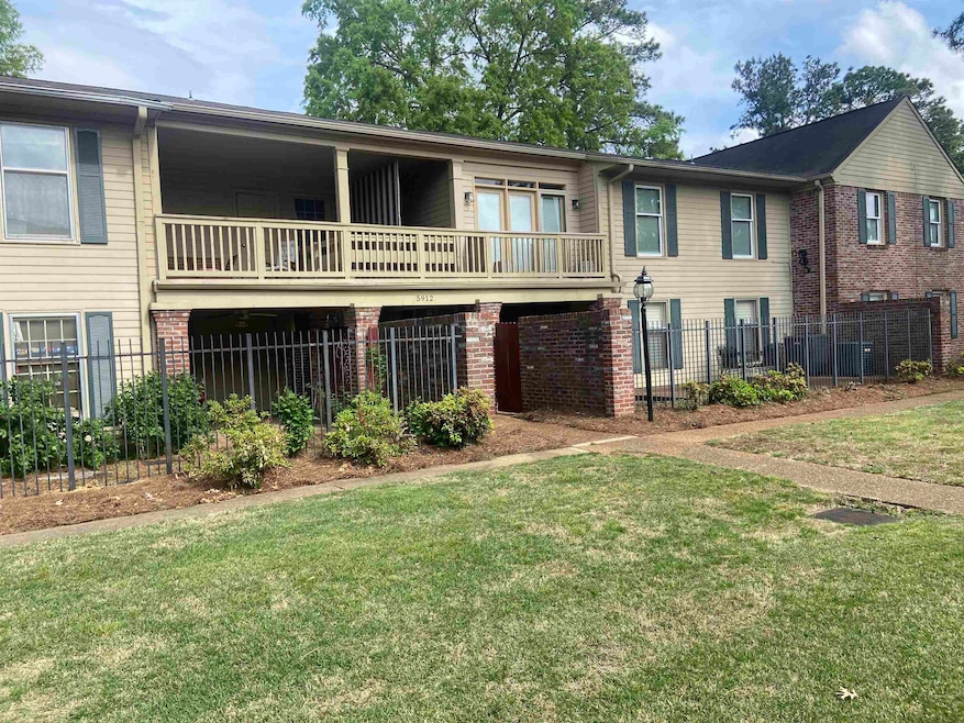 Rear view of house with fence, a lawn, a balcony, 