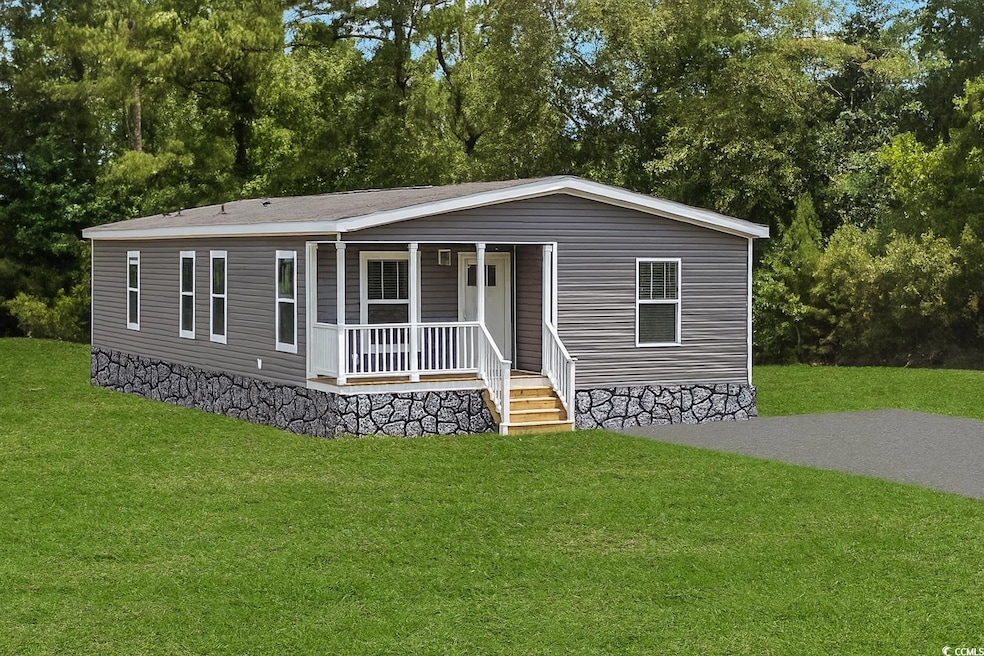 Manufactured / mobile home featuring covered porch and a front lawn