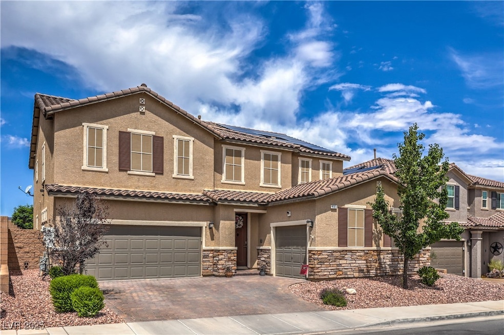 Exterior of home showing paver driveway, 3 car gar