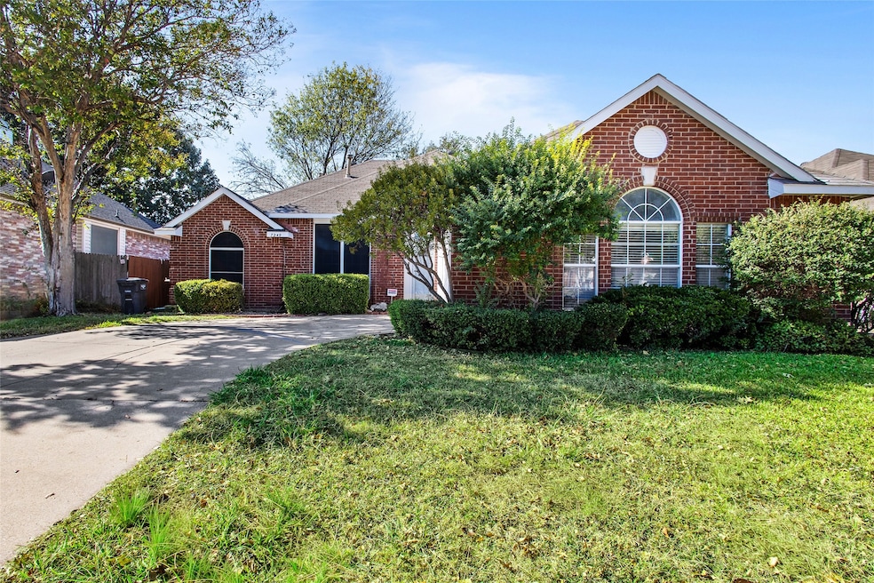 View of front of property with brick siding, a front lawn, and concrete driveway